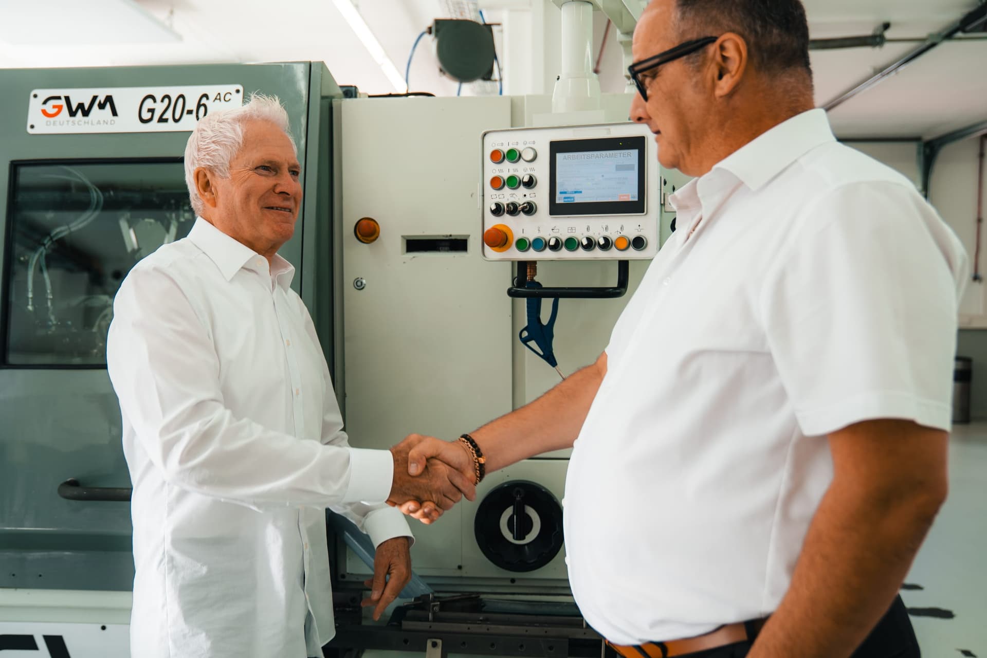 Handschlag an der Maschine in der GWM-Halle